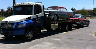 J&S towing truck providing antique towing services to two vehicles